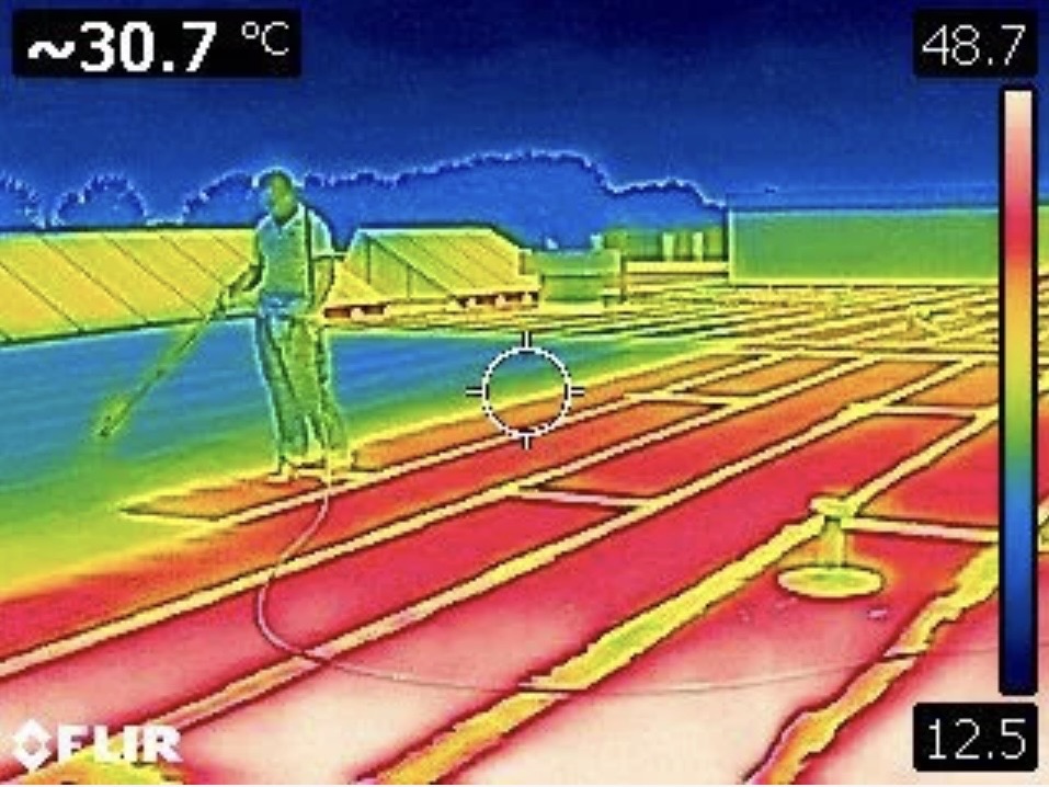 Thermische opname van een koel wit dak versus een warm donker dak